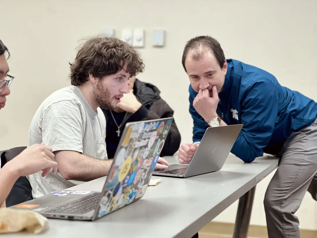Two SWECC members comparing code on their laptops